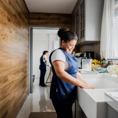 Housekeeper washing dishes in a house