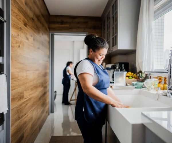 Housekeeper washing dishes in a house